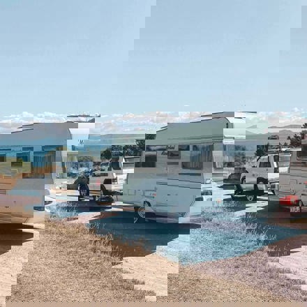 SUV towing a caravan on a gravel road, caravan finance, motorhome finance